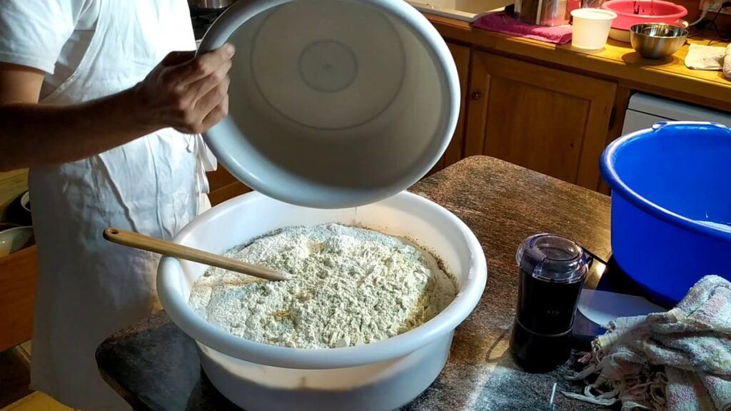 Ajout de la farine au levain pour préparer la pâte à pain